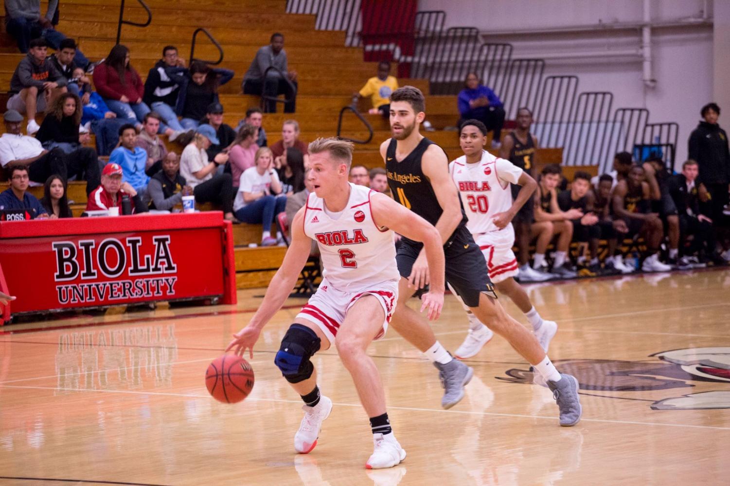 Junior forward Levi Auble dribbles past a Cal State LA defender on November 10, 2018.