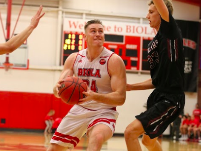 a male player begins to make a layup against a blocking player