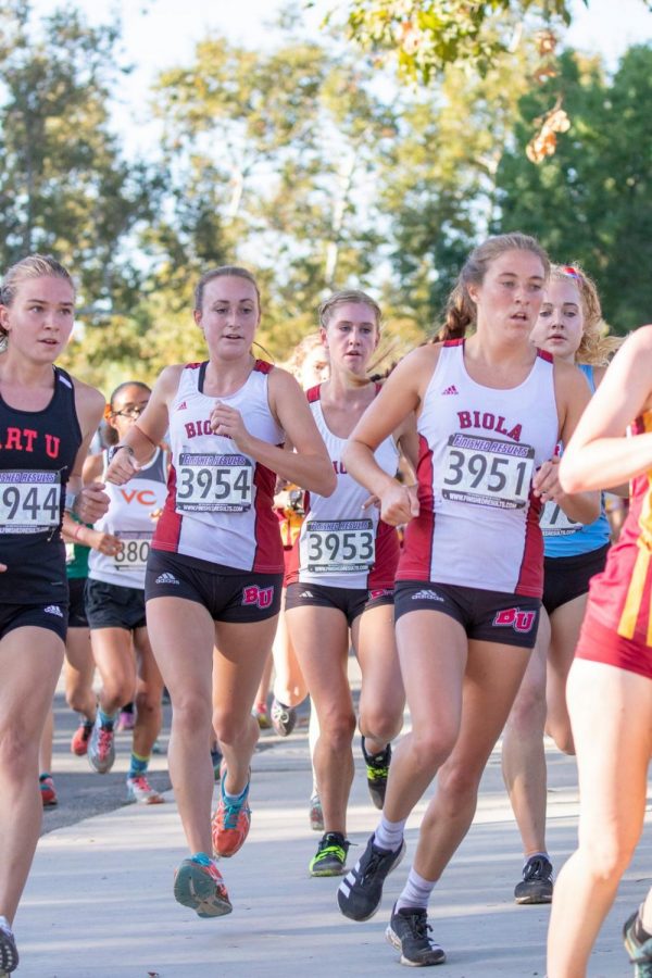 Biola womens cross country athletes run among their fellow teammates. 