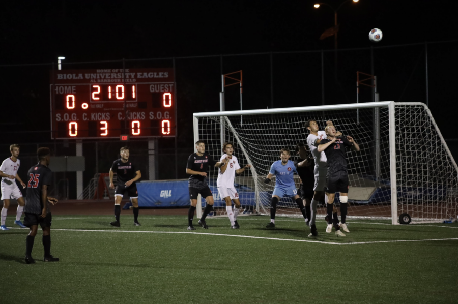 The Biola men's soccer team tries to get the ball into the net after a corner kick.  