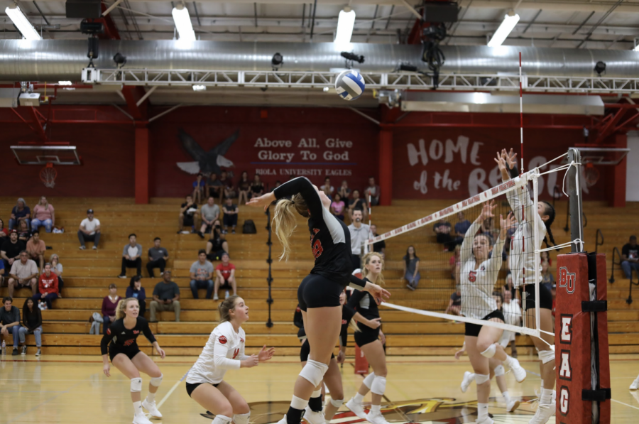 Biola+Volleyball+player+jumps+to+spike+the+ball.+