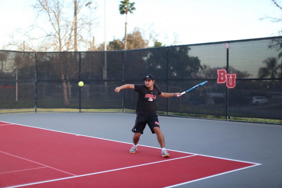 Andres Meneses, a sophomore business major, prepares to swing at the ball.