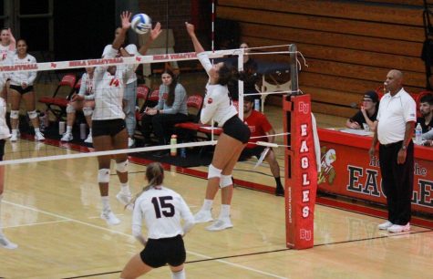Sophomore right side Anna Aubele jumps to block and senior outside hitter Emily Smith crouches to defend as Dominican sets the ball. 