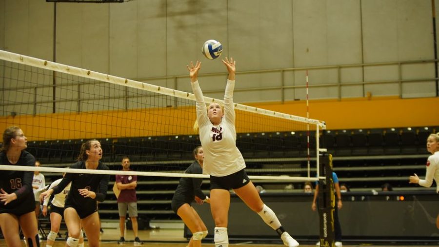 Redshirt senior setter Abby Brewster leaps into the air to set the ball.