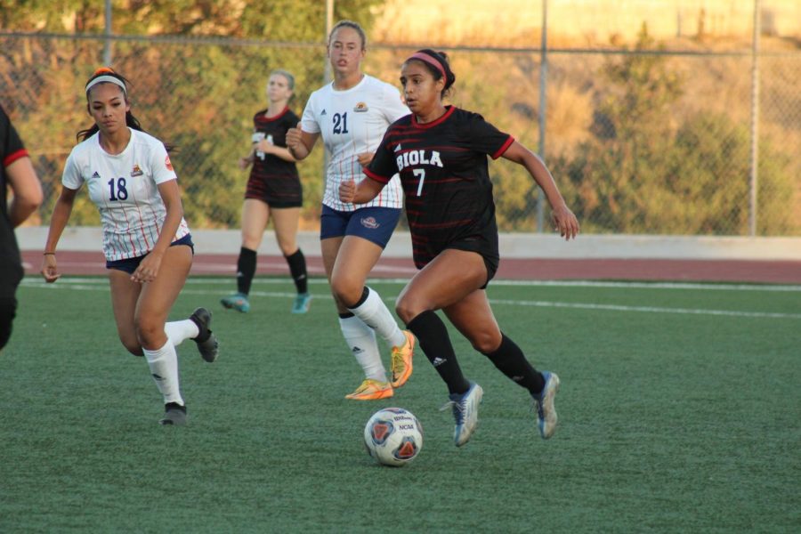 Redshirt senior midfielder Frances Andrade dribbles past two defenders. 