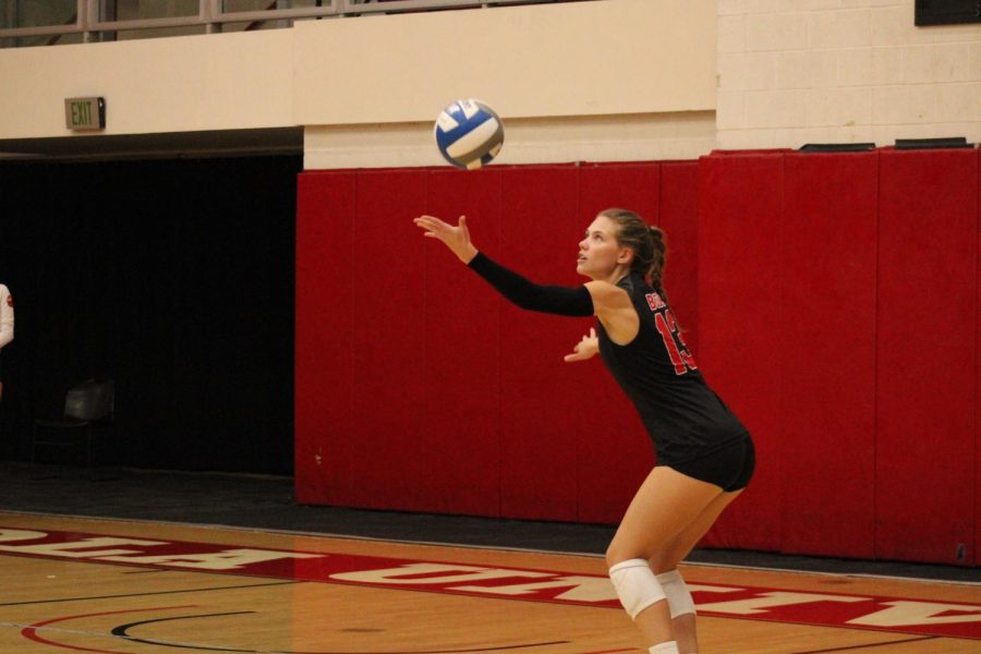 Junior defensive specialist Mary McDonnell tosses the ball in the air to serve. 