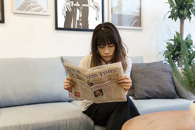 Business_Woman_is_reading_Newspaper_-_35870943420