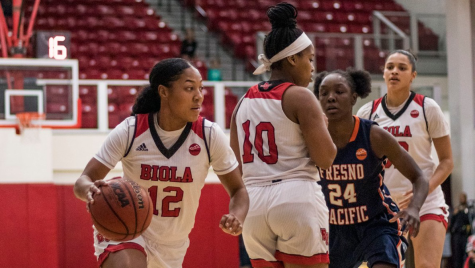 Guard Aysia Johnson dribbles around redshirt sophomore guard Esther Naum and her Fresno Pacific opponent. 