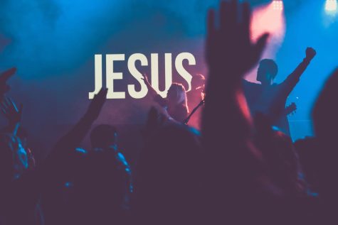 Students raise their hands in worship.