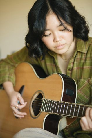 Sophomore psychology major Alisha Kita plays her own music on her guitar. 