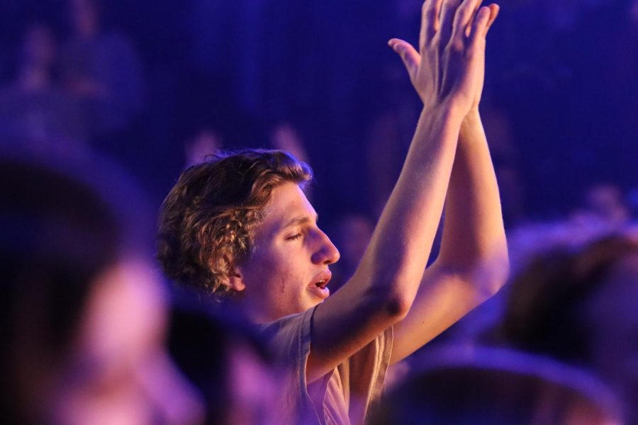 Attendees raise their hands as Met By Love worship leads the crowd in praise.