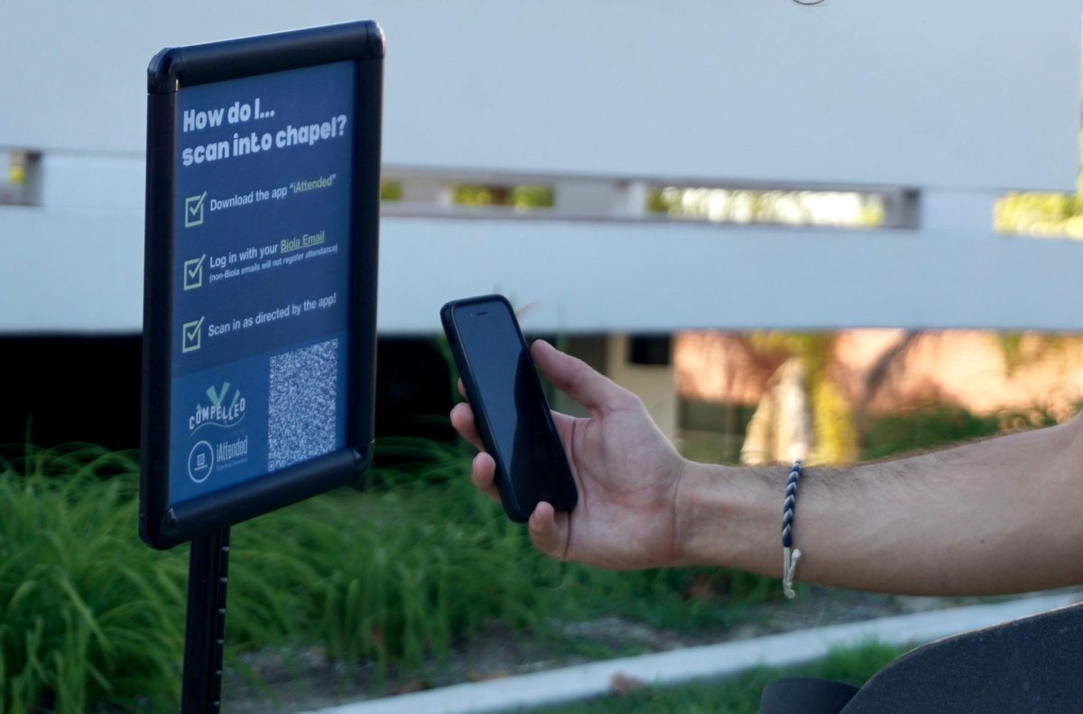 A chapel attendee scans a QR code to download the iAttended app