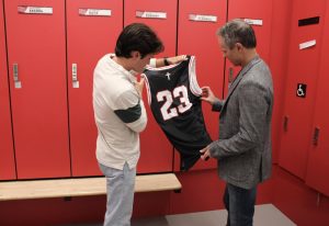 Scott (left) and Sean (right) McDowell inspect Scott’s new basketball jersey