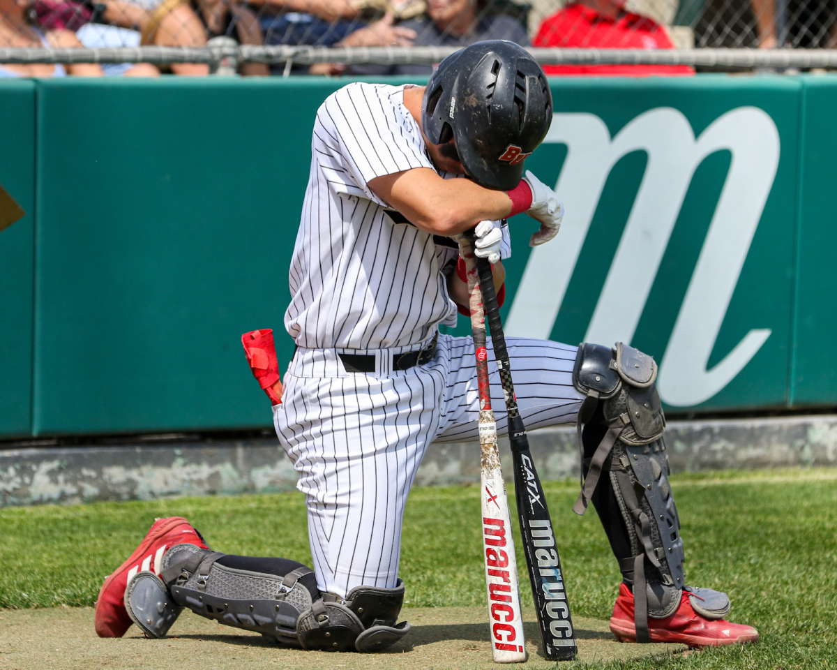 Taylor Justus kneeling in prayer during Biola Baseball game.
