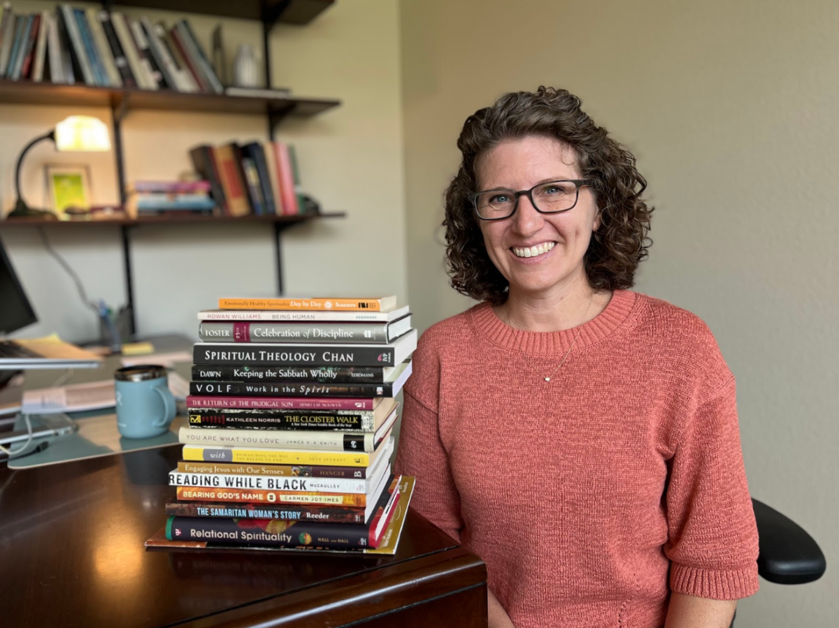 Lisa Igram in her office, surrounded by a stack of her recommended books