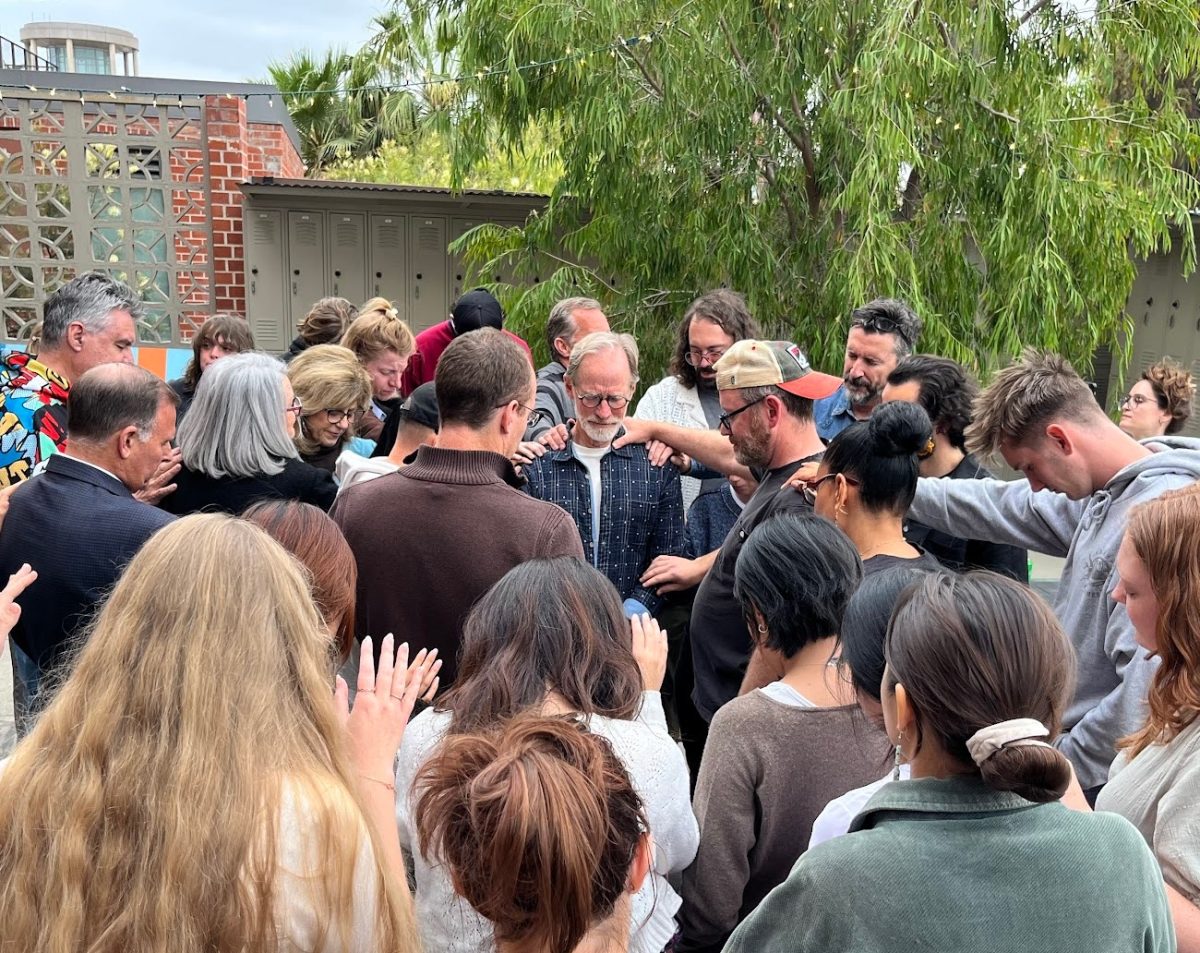 The art department staff, professors and students pray for Dan Callis on April 23, 2025 at the sculpture backyard.